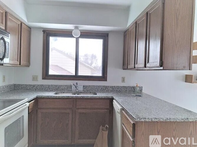 A kitchen with wooden cabinets and a granite countertop.