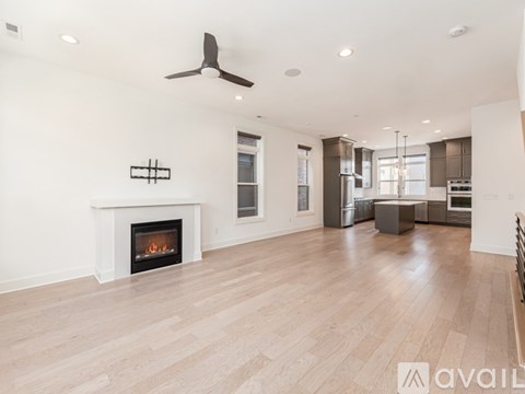 A spacious living room with a fireplace and hardwood floors.