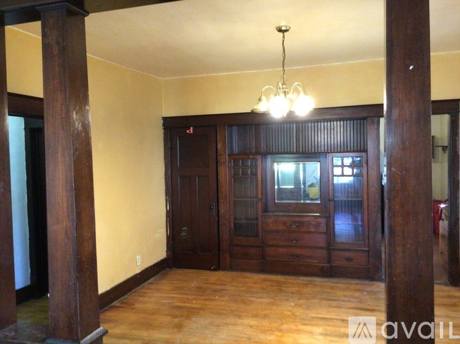 A room with wooden floors and a chandelier hanging from the ceiling.
