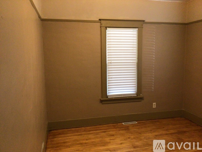 A room with a window and wooden flooring.