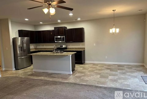 A kitchen with a refrigerator, microwave, and oven is available for rent.