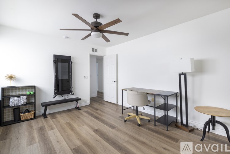 A room with a ceiling fan and a television.
