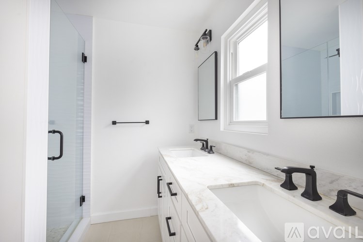A bathroom with a marble countertop and a large mirror.