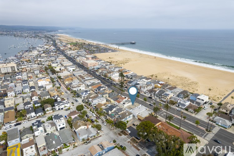 An aerial view of a beachfront town with a blue pin on a specific location.