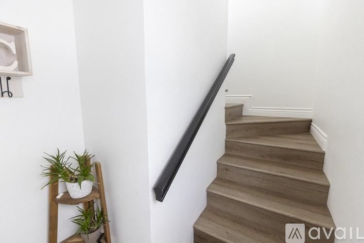 A wooden staircase with a black handrail.