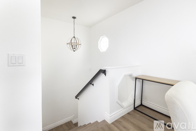 A room with a staircase and a hanging light fixture.