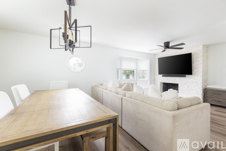 A modern living room with a wooden table and a white couch.