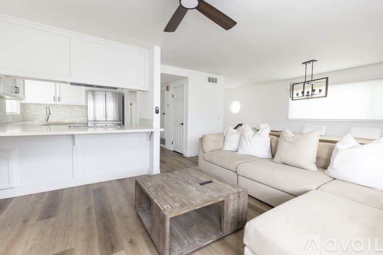 A living room with a white couch and a wooden coffee table.