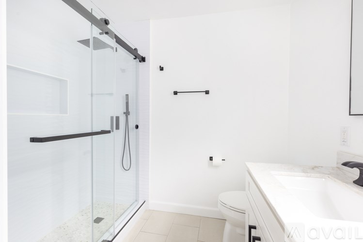 A white bathroom with a walk-in shower and a toilet.