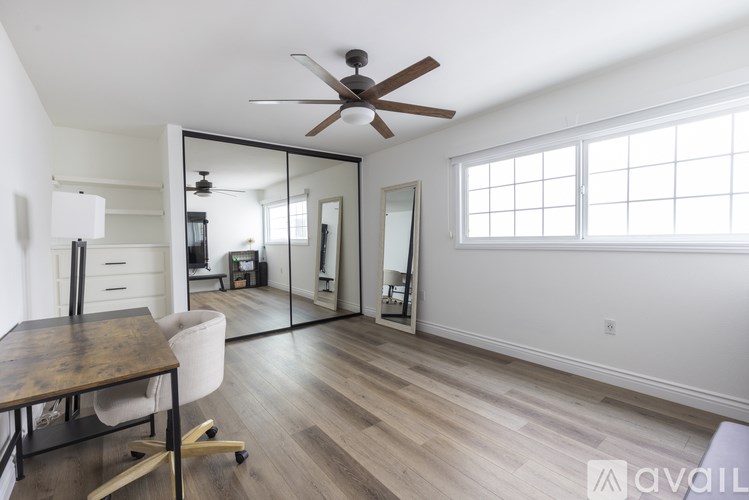 A room with a wooden floor and a ceiling fan.