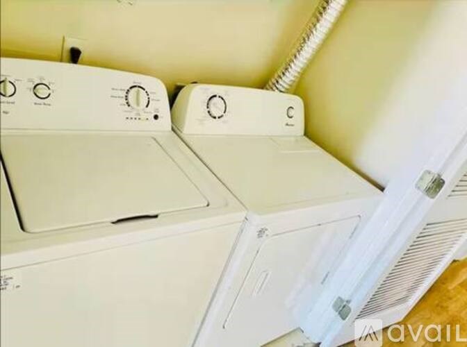 A row of white washing machines are stacked on top of each other.