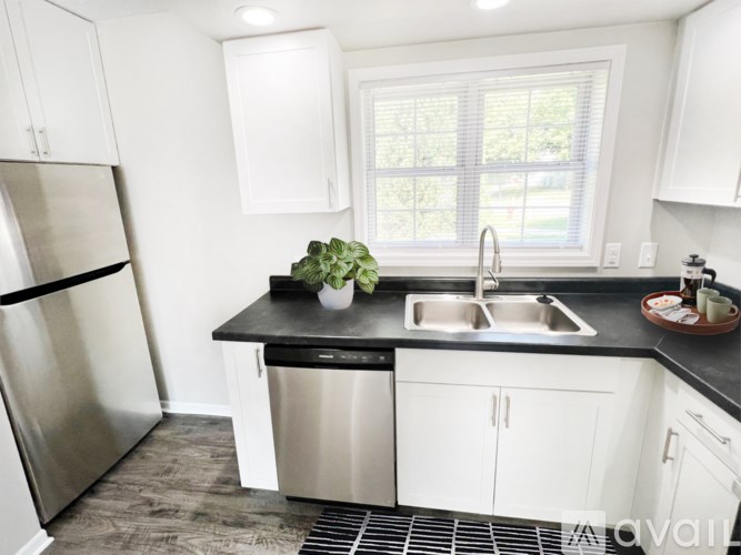 A kitchen with white cabinets and a black countertop.