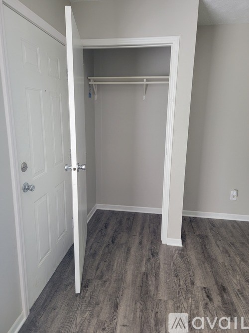 A white closet with a door and a shelf.