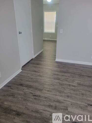 A room with wooden flooring and white walls.