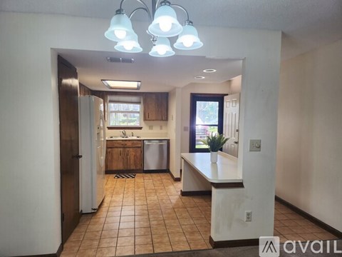 A kitchen with a refrigerator, sink, and a window.