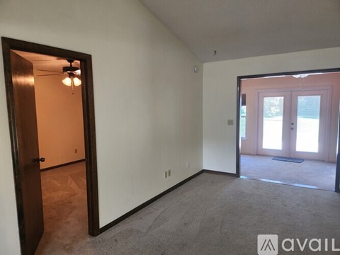 A room with a carpeted floor and a door leading to another room.
