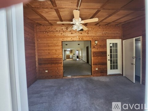A room with wooden walls and a ceiling fan.