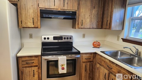 A kitchen with wooden cabinets and a black stove top oven.