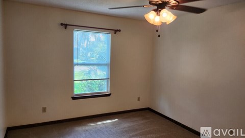 A room with a ceiling fan and a window.