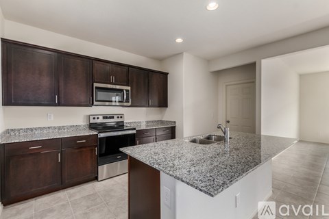 A kitchen with brown cabinets and a granite countertop.
