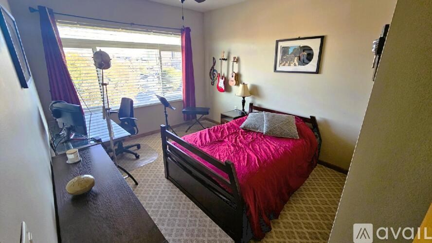 A bedroom with a bed, desk, and chair.