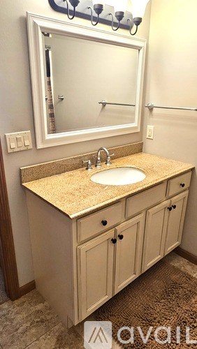 A bathroom vanity with a sink and a mirror above it.