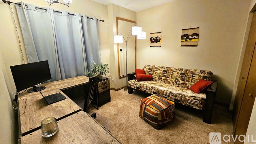 A living room with a couch, a table, a television, and a plant.