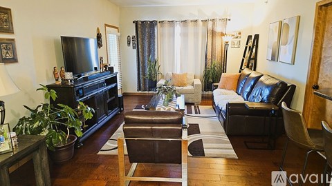 A living room with a black leather couch and a wooden coffee table.