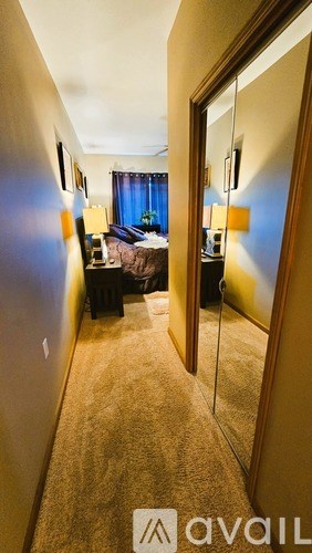 A bedroom with a bed, nightstand, and lamp.