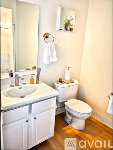 A white bathroom with a toilet, sink, and mirror.