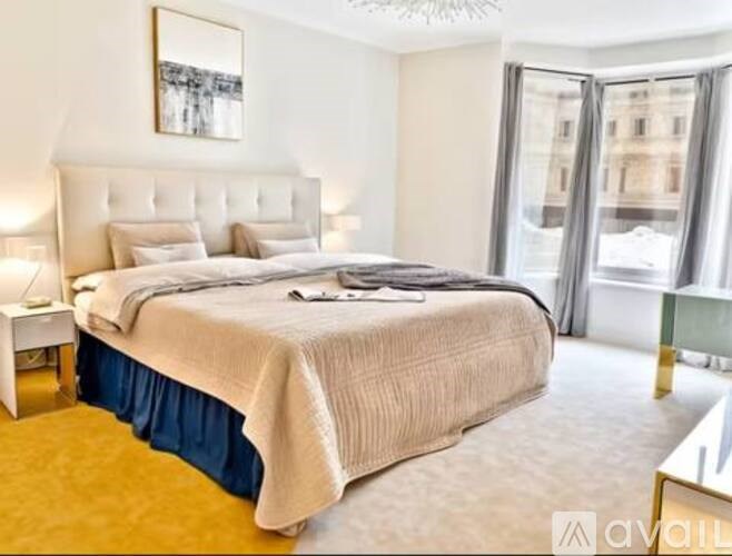 A bedroom with a large bed and a painting on the wall.