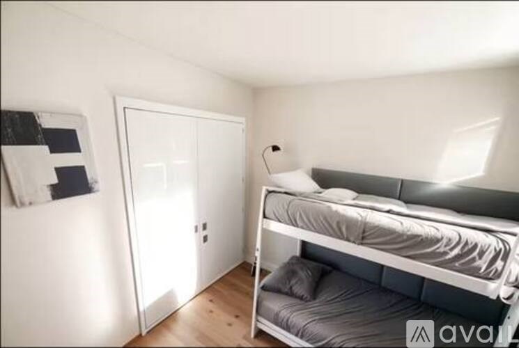 A bedroom with a bed, a nightstand, and a door.