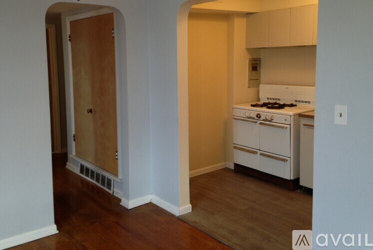 A kitchen with white appliances and wooden floors.