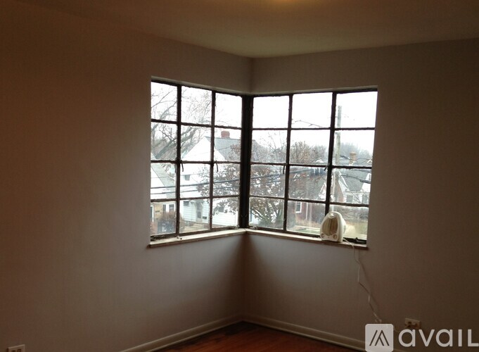 A room with a large window overlooking a residential area.