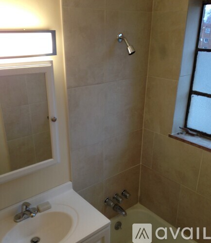 A bathroom with a sink, mirror, and shower.