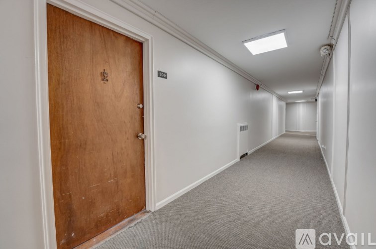 A long hallway with a wooden door at the end.