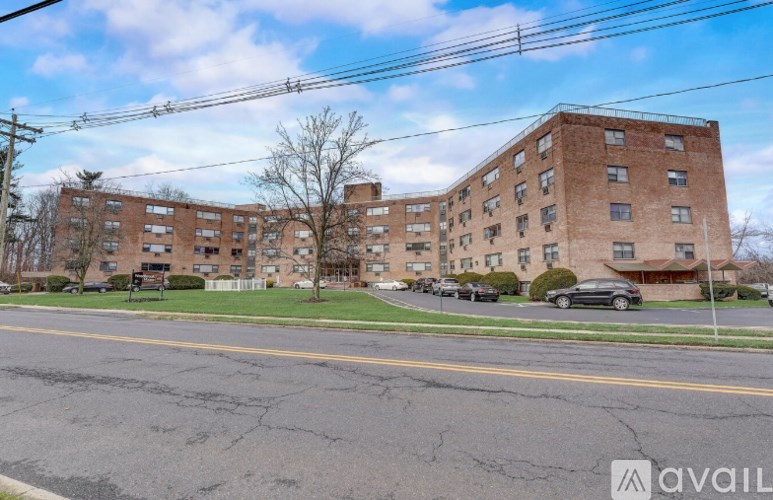 A large brick apartment building with a parking lot in front.