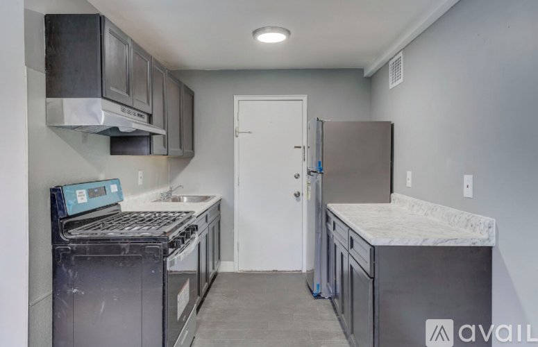 A kitchen with a stove top oven and a refrigerator.