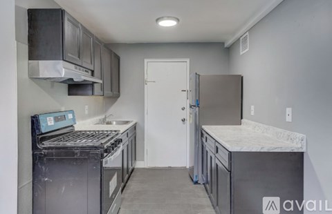 A kitchen with a stove top oven and a refrigerator.