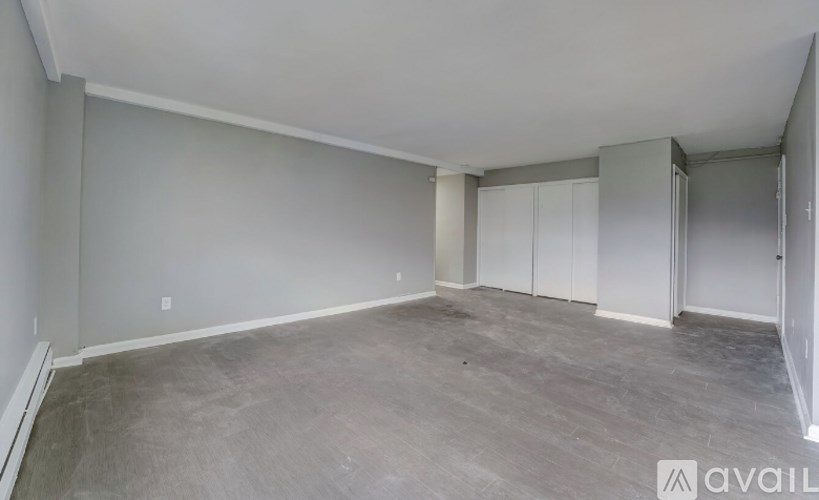 A spacious room with grey flooring and white walls.