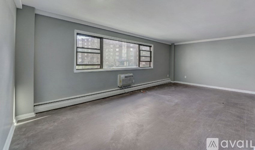 A room with grey walls and a window overlooking a cityscape.