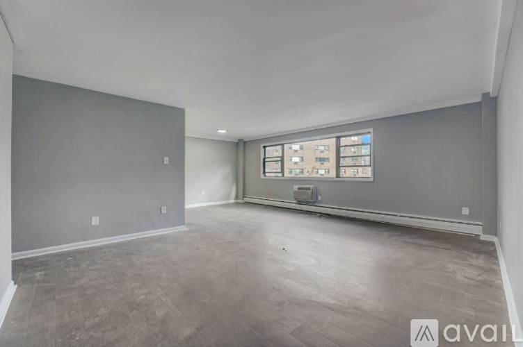 A spacious room with grey walls and a large window.