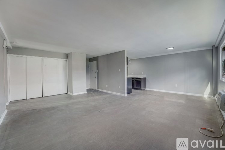 A spacious empty room with a fireplace and a wall-mounted TV.