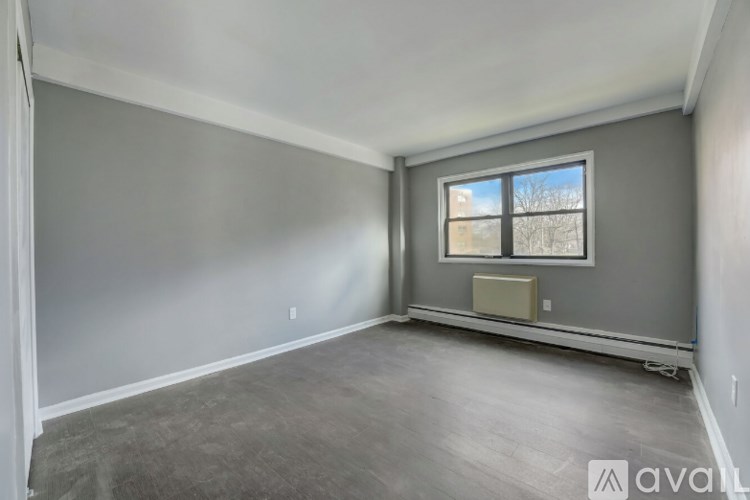 A room with a window and a picture frame on the wall.