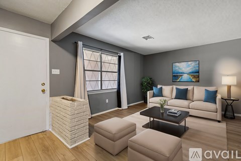 A living room with a couch, a coffee table, and a painting on the wall.