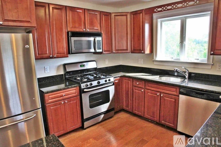 A kitchen with wooden cabinets and a stainless steel refrigerator.