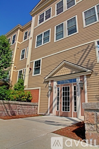 A building with a brown facade and a stone wall in front.