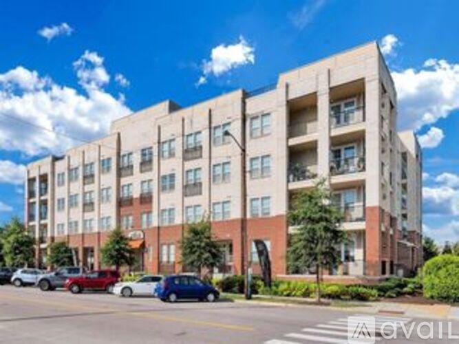 A large apartment building with cars parked in front.