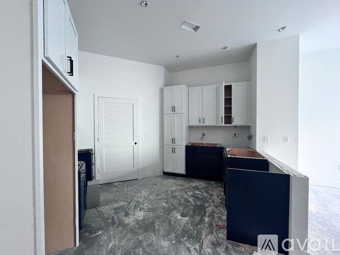 A kitchen with white cabinets and a marble floor.