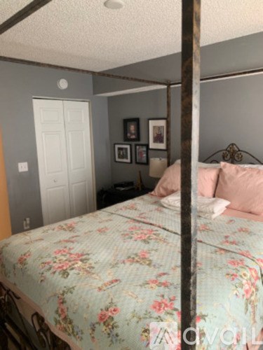 A four poster bed with a floral bedspread.